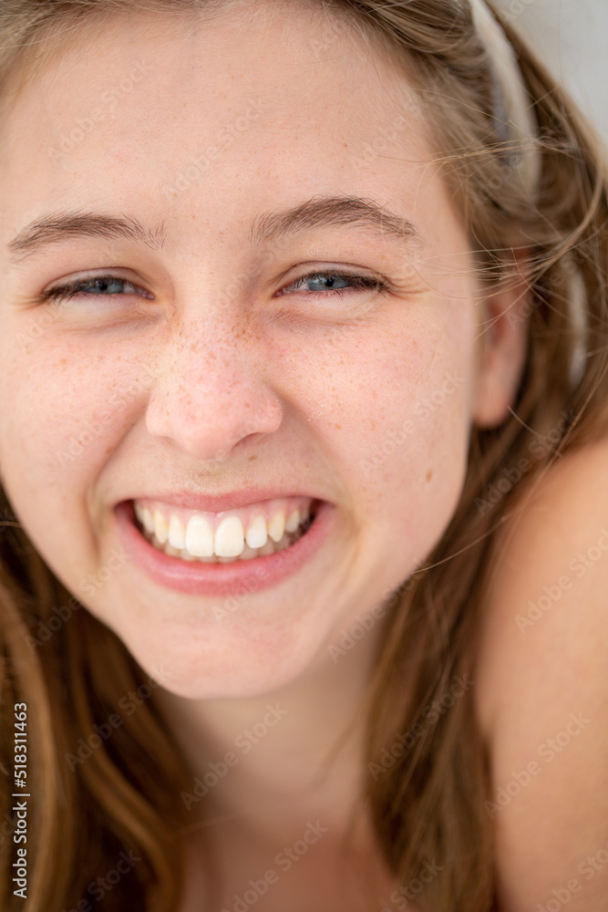 Teenager with cheesy grin and grains of sand on her face Teenager with cheesy grin and grains of sand on her face