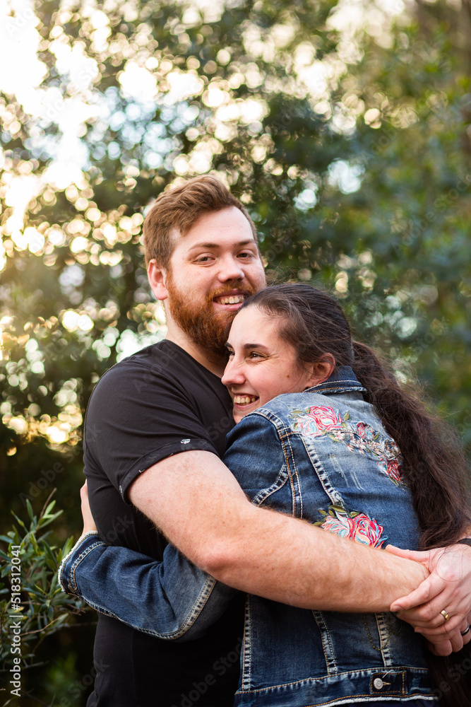 Happy young people hug with man looking at the camera Happy young people hug with man looking at the camera
