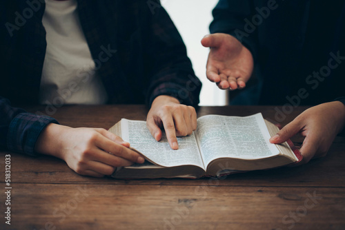  Two Christian friends read and study the bible at home and pray together. Studying the Word Of God With Friends.Sunday readings, concept studying the word of god. photo