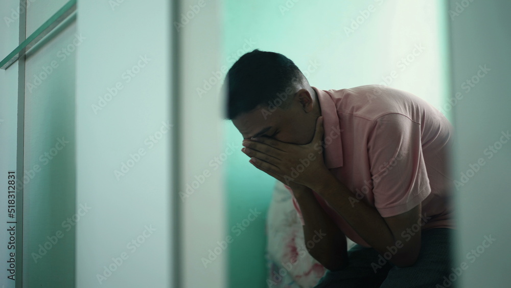 Anxious young man covering face suffering from mental illness. Mirror reflection of frustrated hispanic young man feeling emotional pain Anxious young man covering face suffering from mental illness. Mirror reflection of frustrated hispanic young man feeling emotional pain