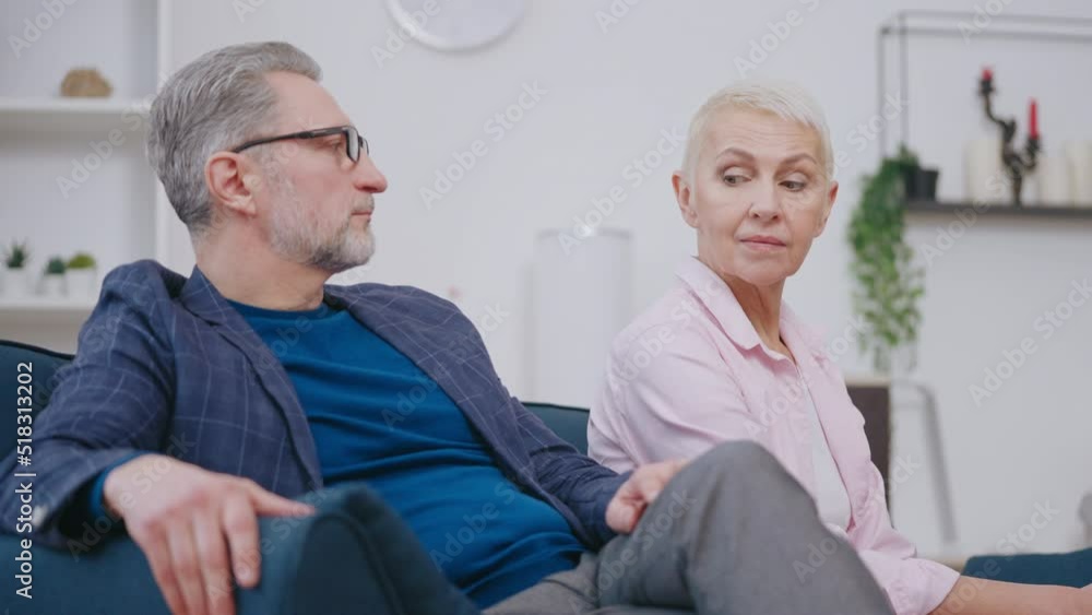 Offended couple in their 50s sitting apart at psychologist session, conflict Offended couple in their 50s sitting apart at psychologist session, conflict