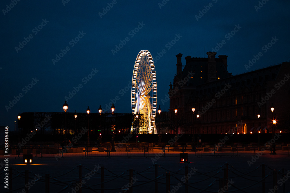 Fotografia noturna com roda gigante iluminada em Paris