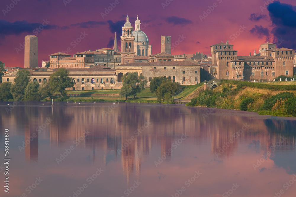 Fototapeta premium View of the city of Mantua at sunset reflected on the Middle Lake on the Mincio River