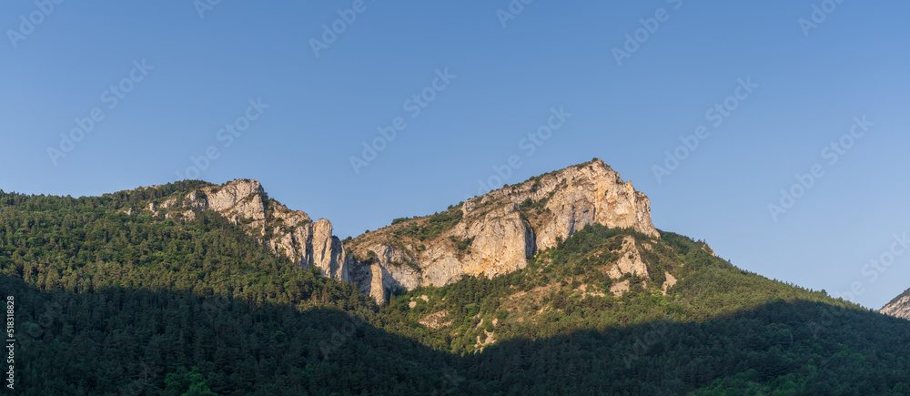 Scenic summer afternoon landscape panoramic view of rocky mountain ridge and forest under bright blue sky in the Boulzane river valley near Gincla, Aude, France