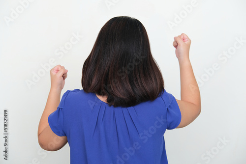 Back view of Asian woman clenched fist showing happiness photo