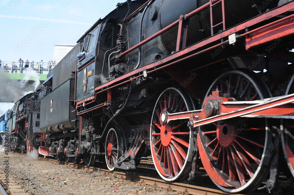 Retro historical antique steam locomotive running on rail tracks and puffing with smoke and steam in Wolsztyn, Poland, Europe Retro historical antique steam locomotive running on rail tracks and puffing with smoke and steam in Wolsztyn, Poland, Europe