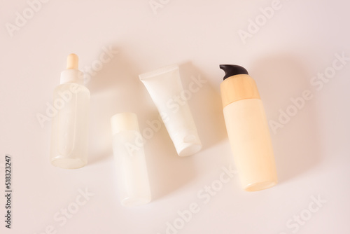 Cosmetic bottles on pastel beige background