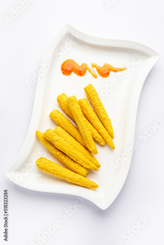 Crispy fried baby corn pakoda, pakora  or Baby corn fritters served with ketchup, Indian food photo