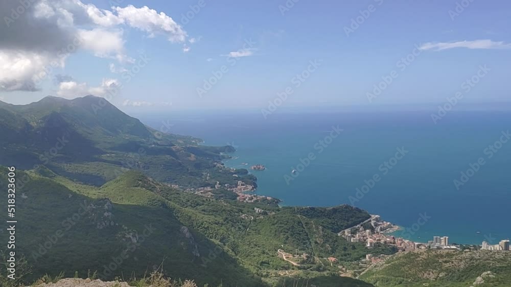 Panoramic view of Budva city from above, Montenegro. View of landscape mountainside by the sea with historic houses near the coastline. Touristic resort town with green vegetation on summer day Panoramic view of Budva city from above, Montenegro. View of landscape mountainside by the sea with historic houses near the coastline. Touristic resort town with green vegetation on summer day