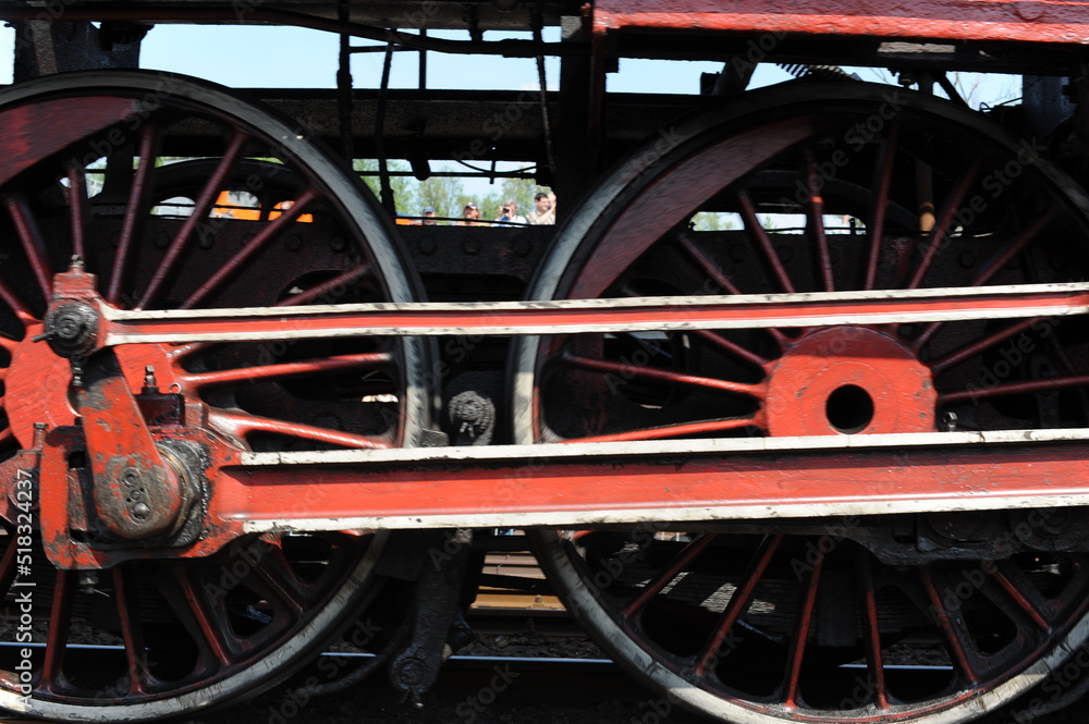 Red and black iron wheels of a running old steam locomotive