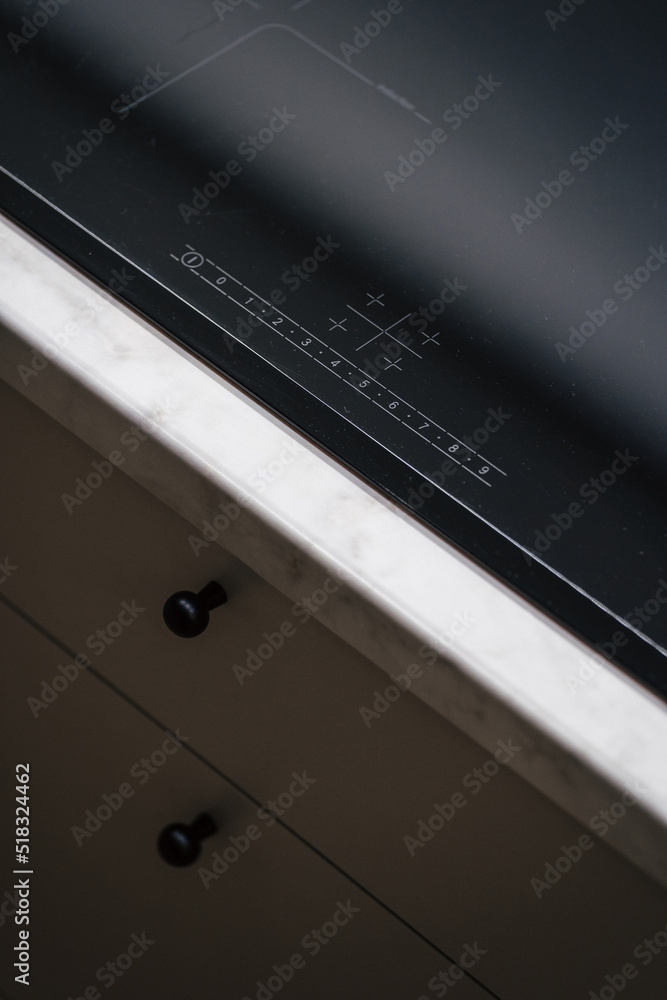 Buttons of black induction cooker in kitchen interior Buttons of black induction cooker in kitchen interior