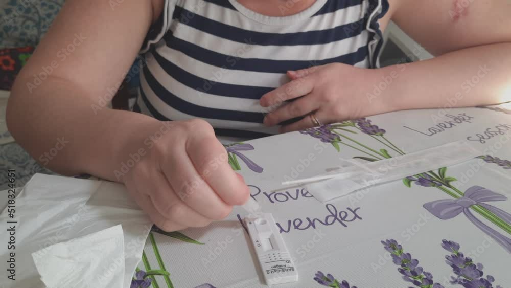 Woman drops a few drops from the tube containing the liquid solution, onto the antigen test cassette for the covid corona virus at home. SARS-CoV-2 Antigen Rapid Test. Real time video.