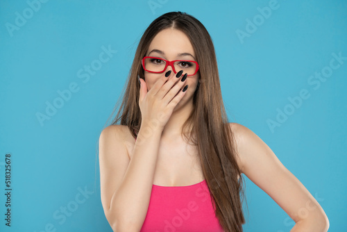 Fényképezés Young woman laughing and embarrassed giggle covering mouth with hands, gossip an