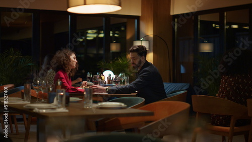 Fototapeta Naklejka Na Ścianę i Meble -  Mixed race couple dating in fancy restaurant table. Lovers enjoy time together.