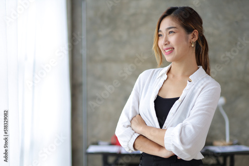 Portrait of a charming Asian businesswoman standing looking away contemplating and imagining success.