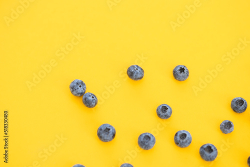 Colorful fruit pattern of blueberries on yellow background