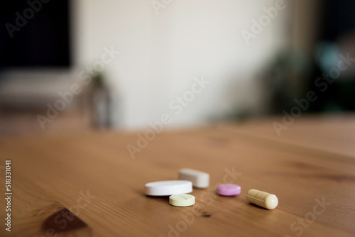 Various pills on a wooden table