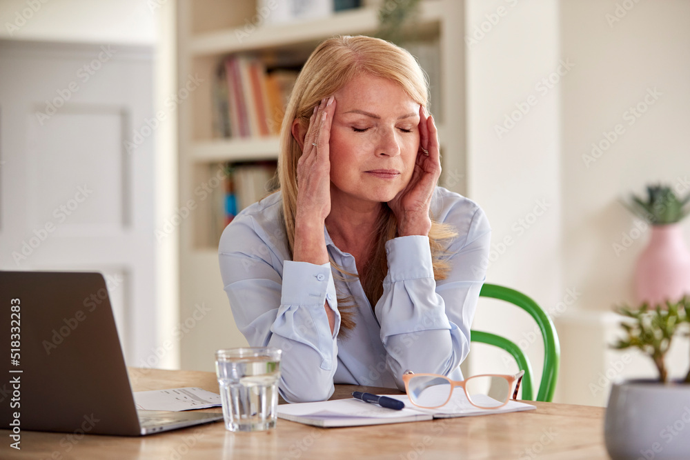 Menopausal Mature Woman Working On Laptop At Home Suffering With Headache Pain Menopausal Mature Woman Working On Laptop At Home Suffering With Headache Pain