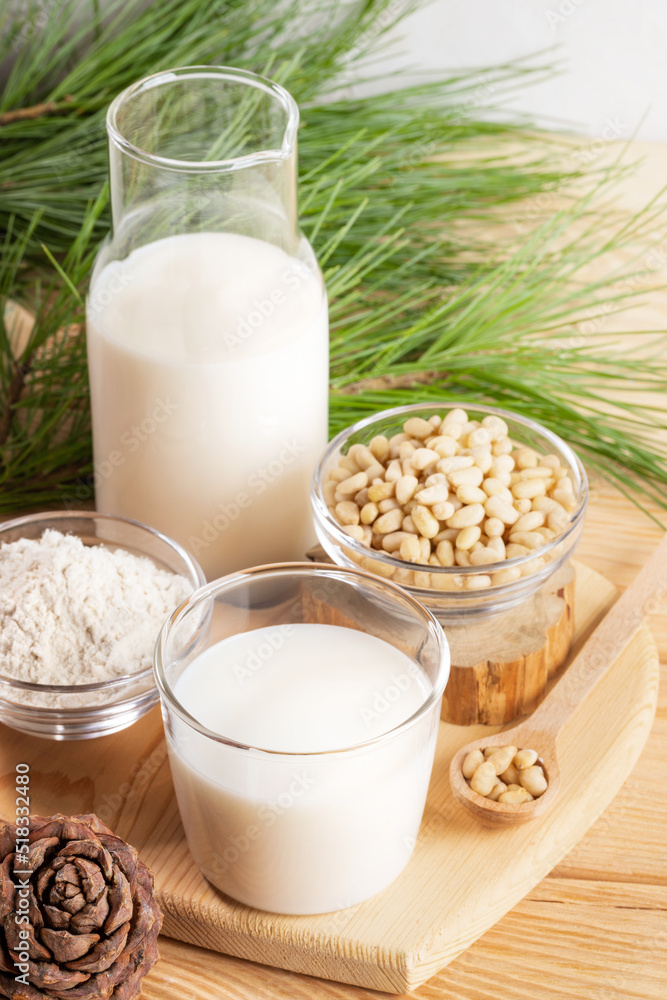 Cedar nut products: milk in glass and bottle, nuts and powder on wooden table. Selective focus. Cedar nut products: milk in glass and bottle, nuts and powder on wooden table. Selective focus.