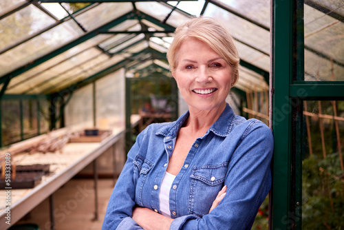 Portrait Of Mature Woman Gardening In Greenhouse At Home photo