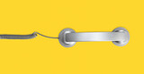 Telephone handset isolated on yellow background. Contact us banner. Top view