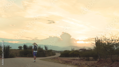young man traveling with backpack in dry desert at sunset, enjoying the landscape in Colombia, tatacoa desert