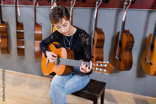 Musician playing acoustic guitar in music store.