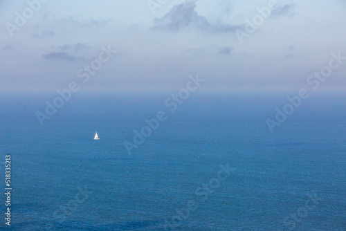 A view over the ocean off the Sussex coast with a sailing boat on the calm water