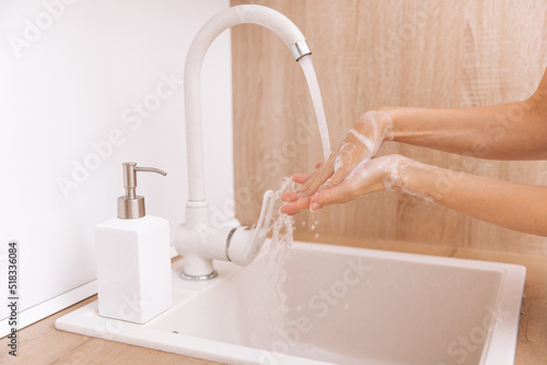 Washing hands under the flowing water tap. Washing hands rubbing with soap for corona virus prevention  hygiene to stop spreading corona virus in or public wash room. Hygiene concept hand detail