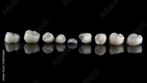 ceramic dental crowns for chewing teeth on black glass with creative reflection