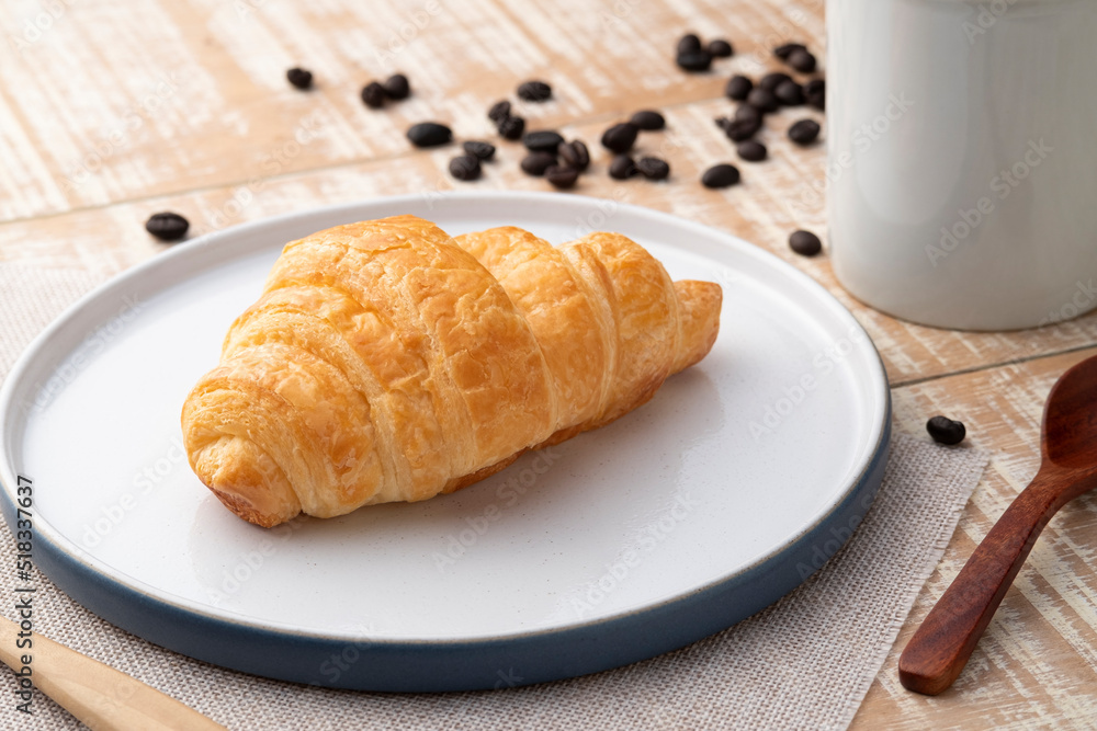 Croissant margarine with coffee cup on wooden background