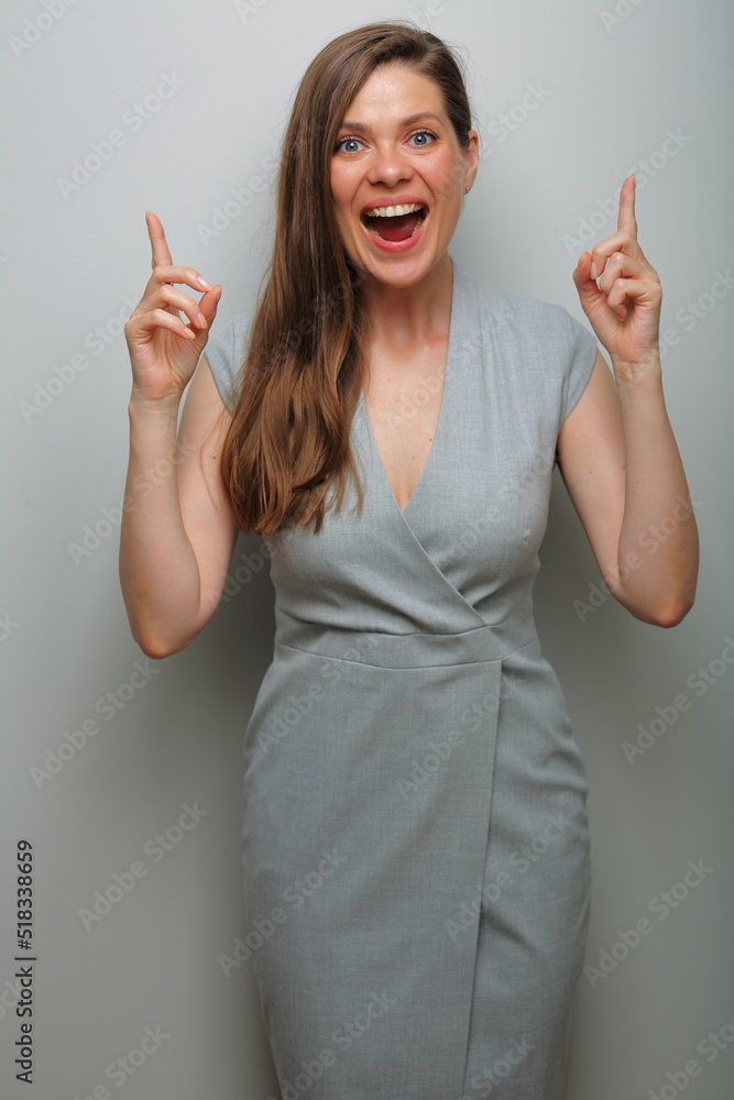 Smiling woman pointing finger up. Gray business dress. Smiling woman pointing finger up. Gray business dress.