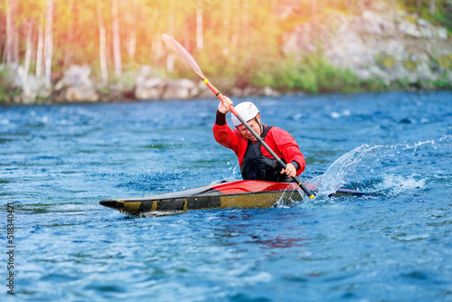 Whitewater kayaking, extreme sport rafting. Guy in kayak sails mountain river