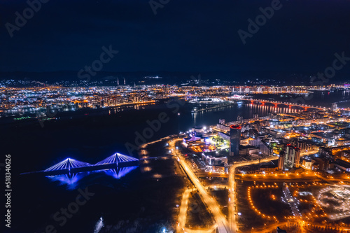 Aerial top view city Krasnoyarsk bridge through Yenisei river evening with neon light photo