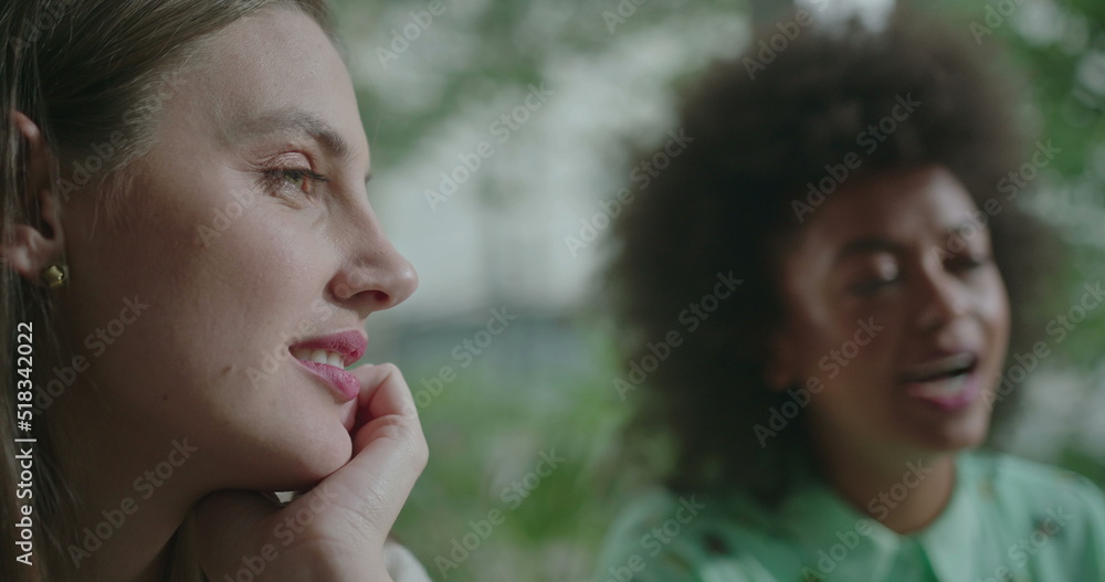 Female diverse friends hanging out together. Closeup of young women faces speaking in conversation. People at coffee shop communicating and chatting