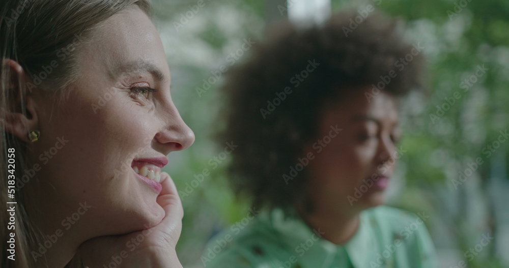 Fototapeta premium Female diverse friends hanging out together. Closeup of young women faces speaking in conversation. People at coffee shop communicating and chatting