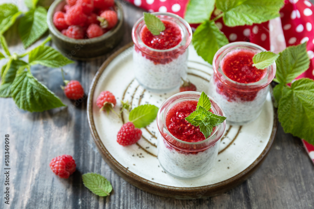 Healthy breakfast. Glass jars with chia pudding with raspberry and jam or smoothies with chia seeds on rustic table. Healthy breakfast. Glass jars with chia pudding with raspberry and jam or smoothies with chia seeds on rustic table.