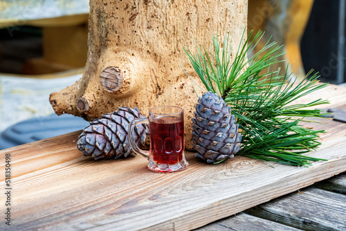 Fotografia a glass swiss stone pine schnapps, cones and twigs from the swiss stone pine or
