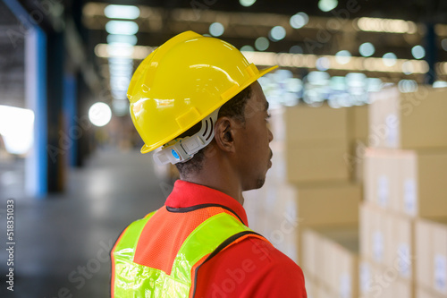 Portrait of young mixed race male worker wearing helmet in modern warehouse storage of retail shop © tonefotografia