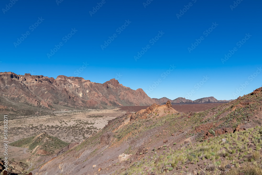 Panoramic view on Roque del Almendro, El Sombrero in volcano Mount Teide National Park, Tenerife, Canary Islands, Spain, Europe. Volcanic barren desert landscape. Scenic hiking trail on sunny day