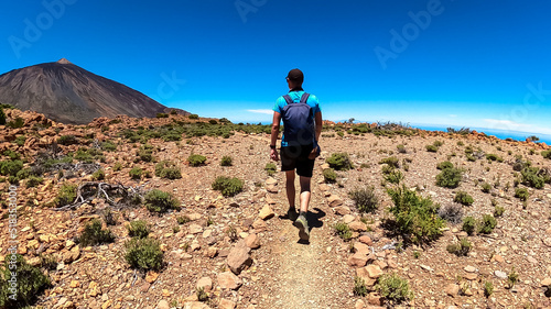 Man on hiking trail to summit Riscos de la Fortaleza with scenic view on volcano Pico del Teide, Mount Teide National Park, Tenerife, Canary Islands, Spain, Europe. Via La Canada de los Guancheros photo