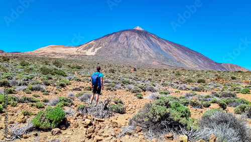 Active man on La Canada de los Guancheros dry desert plain with view on volcano Pico del Teide, Mount El Teide National Park, Tenerife, Canary Islands, Spain, Europe. Hiking to Riscos de la Fortaleza