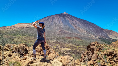 Woman on summit of Riscos de la Fortaleza with panoramic view on volcano Pico del Teide, Mount El Teide National Park, Tenerife, Canary Islands, Spain, Europe. Hike via La Canada de los Guancheros photo