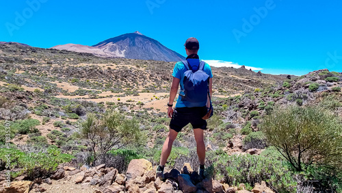 Active man on La Canada de los Guancheros dry desert plain with view on volcano Pico del Teide, Mount El Teide National Park, Tenerife, Canary Islands, Spain, Europe. Hiking to Riscos de la Fortaleza photo