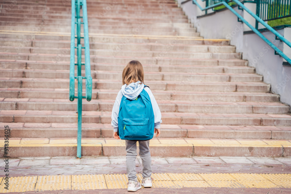 Back to elementary primary school. Little girl with big backpack