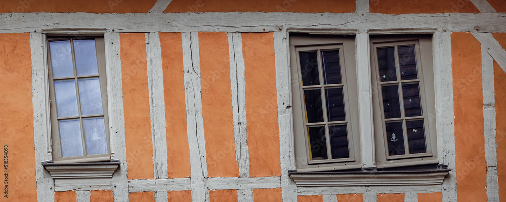 Obraz premium Half timbered house background with brown yellow pattern of wood and plaster and crooked windows