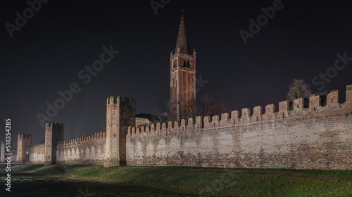 Montagnana by night, a small medieval village in the province of Padua, with the characteristic walled walls with fortification towers that refer to the castle, you can see the bell tower of the churc