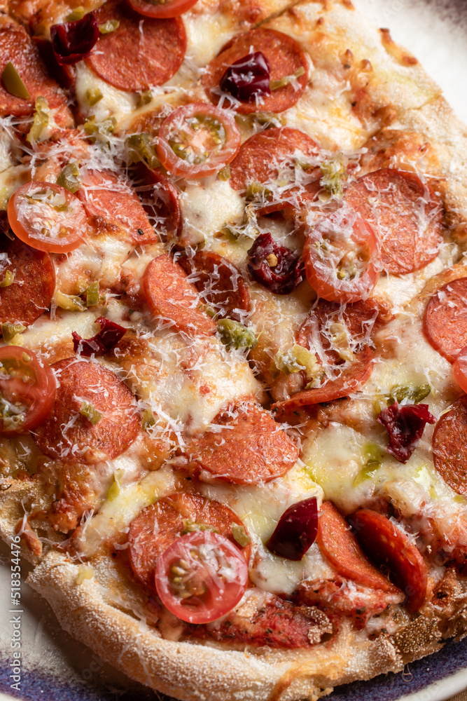 Roman pizza with salami, cherry tomatoes and parmesan close-up Roman pizza with salami, cherry tomatoes and parmesan close-up