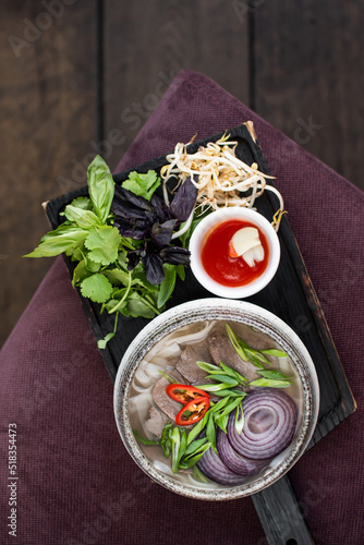 Vietnamese Pho Bo soup with beef hot peppers, lots of greens and bread. asian food