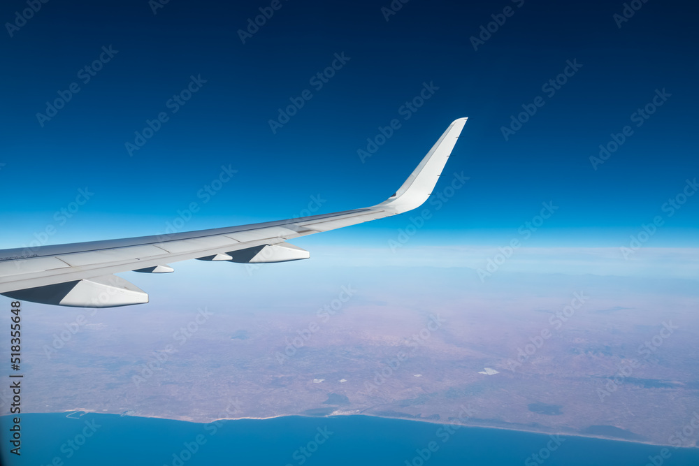 Aerial window view from an airplane on the African coast of Morocco. Hill and mountain landscape. Flying high above ground. Freedom. Coastline of Atlantic Ocean. Commercial flight from Canary Islands Aerial window view from an airplane on the African coast of Morocco. Hill and mountain landscape. Flying high above ground. Freedom. Coastline of Atlantic Ocean. Commercial flight from Canary Islands